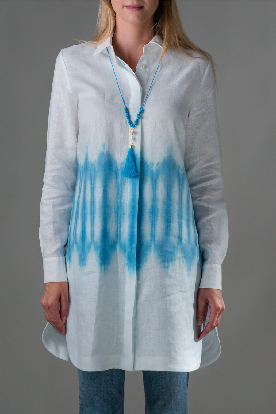Bela lanena srajca Arashi s modrim shibori odtenkom iz nove Ta'Shi kolekcije je primerna za vroče poletne dni, obiske tržnice in sprehode ob morju